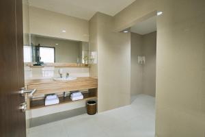 y baño con lavabo y espejo. en Horison TC UPI Serang, en Banjar