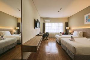 a hotel room with two beds and a desk at Horison TC UPI Serang in Banjar +48 photos