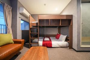 um quarto com um beliche e um sofá em Residence Hotel Stripe Sapporo em Sapporo