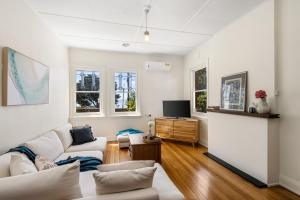 uma sala de estar com um sofá e uma televisão em Waterfront Bliss Family Retreat em Geelong