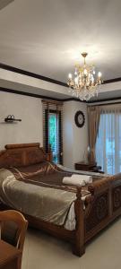 een slaapkamer met een groot bed en een kroonluchter bij บ้านเรือสำราญ in Ban Nong Ket Yai