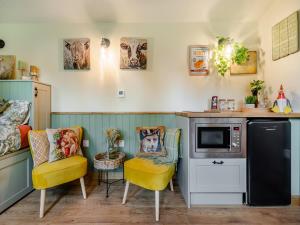 a kitchen with two chairs and a counter with a microwave at Cherry Tree Lodge- Uk45518 in Humberstone