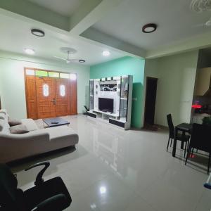 a living room with a couch and a tv at Aanirustayinn in Hoarafushi