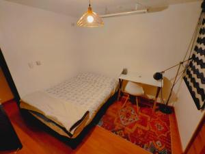 a small bedroom with a bed and a desk at Awesome view and functional in the mountain ! in Bogotá