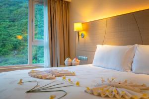 une chambre d'hôtel avec un lit et des serviettes. dans l'établissement Ocean View Resort Yalong Bay, à Sanya
