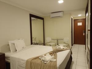 Habitación de hotel con cama y mesa en PONTA NEGRA FLAT APART, en Natal