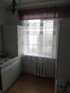 een keuken met een raam met een gordijn bij 2-х квартира Огнівка in Poltava
