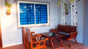 カンポットにあるKampot Nature Villa Resortのテーブルと椅子、窓が備わる客室です。