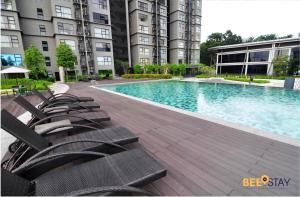 una piscina con tumbonas frente a un edificio en HYVE SOHO Cyberjaya by BeeStay Management en Cyberjaya