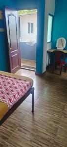 Pokój z łóżkiem, drzwiami i stołem w obiekcie kvm rooms and dormitory w mieście Ernakulam