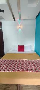 a bed in a room with a red pillow on it at kvm rooms and dormitory in Ernakulam