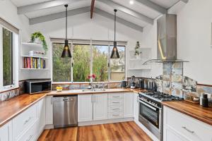 a kitchen with white cabinets and a stove top oven at Summer Cottage in Dunsborough