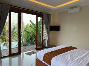 1 dormitorio con 1 cama y balcón con vistas. en Nana Suites Villa en Sidemen