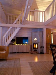 ein Wohnzimmer mit einer Treppe und einem Kamin in der Unterkunft Villa Vilttitossu in Äkäslompolo