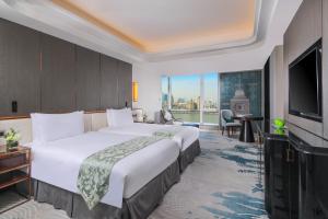 a hotel room with a large bed and a television at Oriental Riverside Bund View Hotel (Shanghai International Convention Center) in Shanghai