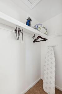 a room with white walls and a shelf with a surfboard at Charming Glenolden Townhouse in Glenolden