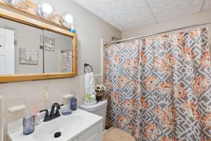 a bathroom with a shower curtain and a sink at Charming Glenolden Townhouse in Glenolden