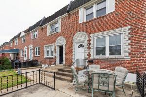 a brick house with a table and chairs in front of it at Charming Glenolden Townhouse in Glenolden