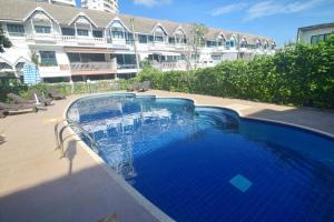 a large blue swimming pool in front of a building at Neverland Hua Hin - Beach Retreat Home in Hua Hin