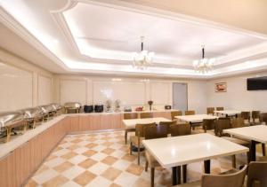 a restaurant with tables and chairs in a room at Vienna International Hotel - Shanghai Jiaotong University Humin Road in Shanghai