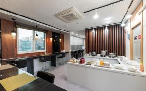 a large kitchen with a counter and a table at Olle Business Hotel in Gwangju