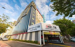 un edificio alto en una calle de la ciudad con en Olle Business Hotel, en Gwangju