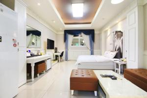 ein Schlafzimmer mit einem Bett und einem Waschbecken in einem Zimmer in der Unterkunft Olle Business Hotel in Gwangju