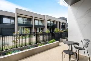 a patio with two chairs and a table in front of a building at 3brm townhouse close to Geelong CBD in Geelong West