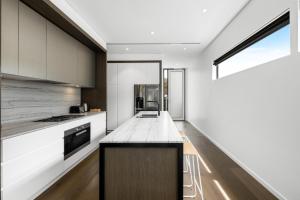 a kitchen with white cabinets and a counter top at 3brm townhouse close to Geelong CBD in Geelong West