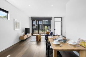 a living room with a wooden table and a dining room at 3brm townhouse close to Geelong CBD in Geelong West