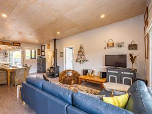 a living room with a blue couch and a television at Our Happy Place - Kinloch Holiday Home in Kinloch