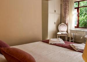 a bedroom with a bed with a chair and a window at Dalyan Terrace Hotel in Dalyan
