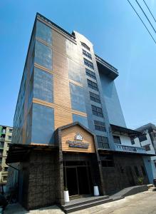 a tall building with a sign in front of it at The Loft Living Space in Samut Prakan