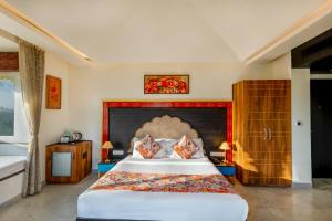 a bedroom with a large bed with a large headboard at Sterling Balicha Udaipur in Udaipur
