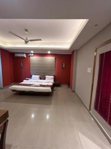 a bedroom with a bed in a room with red walls at NirVana Lodge in Guwahati