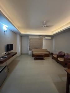 a large living room with a couch and a tv at NirVana Lodge in Guwahati
