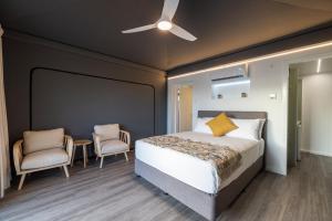 um quarto com uma cama e 2 cadeiras em Townsville Eco Resort 