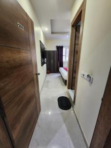 um corredor com uma porta e um quarto com uma cama em Hotel AMBE INN By Ambience Delhi IGI Airport em Nova Deli