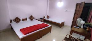 a bedroom with a bed with a red blanket at Pine Shillong Guest House in Shillong