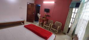 a bedroom with a bed with a red blanket on it at Pine Shillong Guest House in Shillong
