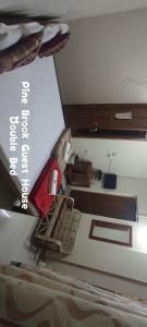 a view of a bedroom with a bed and a cross at Pine Shillong Guest House in Shillong