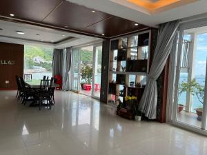 a dining room with a table and chairs and windows at Rio‘s home7 in Vung Tau