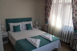 a bedroom with a bed and a window with curtains at Dalyan Terrace Hotel in Dalyan