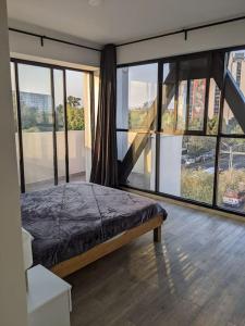 1 dormitorio con 1 cama y grandes ventanas de cristal en Right @Reforma - Beautiful condo with 2 balconies en Ciudad de México
