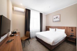 a hotel room with a bed and a television at Freedom hotel Bishkek in Bishkek