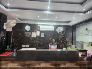 a man standing behind a counter in a restaurant at Hotel AMBE INN By Ambience Delhi IGI Airport in New Delhi
