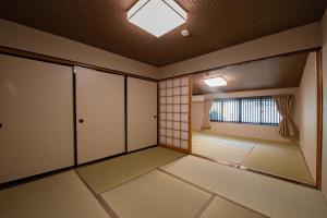ein leeres Zimmer mit einer Tür und einem Fenster in der Unterkunft HIYORI-STAY MatsueBiyori - Vacation STAY 46648v in Matsue