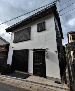 a white building with a black door on a street at Izumo Biyori - Vacation STAY 66967v in Izumo