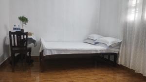 a small bed with white sheets and pillows in a room at VALENTINE'S RICE BOWL HOME STAY in Alleppey