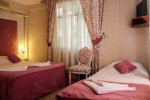 a room with two beds and a chair and a window at Dalyan Terrace Hotel in Dalyan